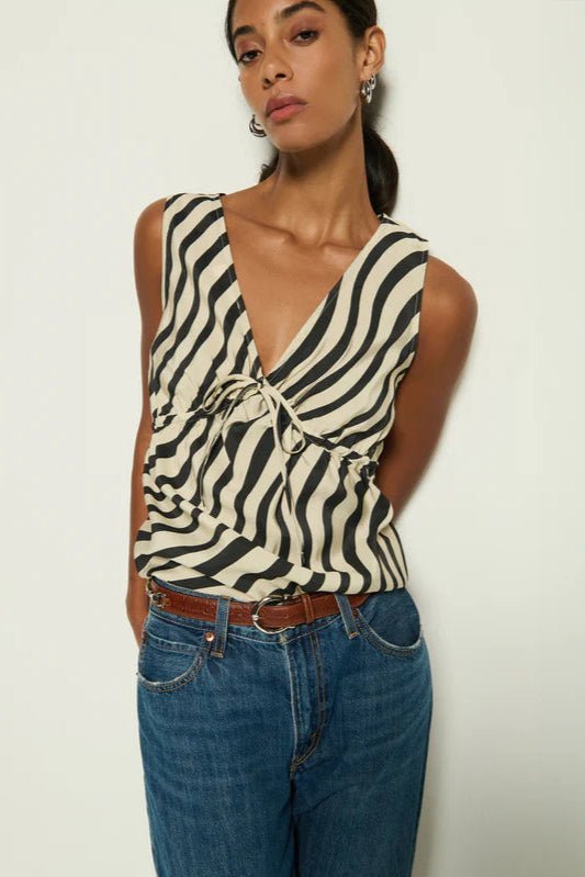 Woman wearing a zebra print top and blue jeans against a white background