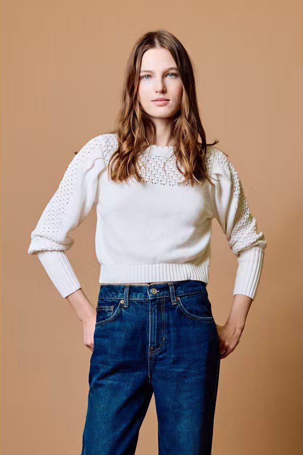 Model wearing the Cleobella Ada sweater in ivory with lattice lace knit yoke and sleeves, styled with dark denim