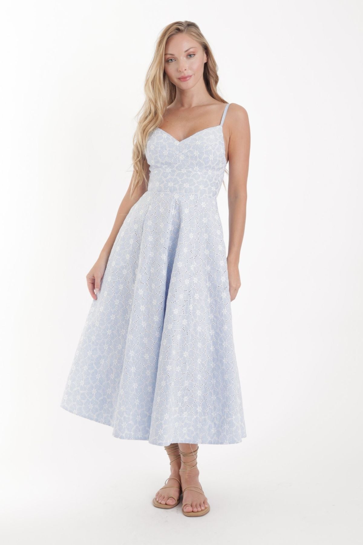 Woman wearing a light blue polka dot dress on a white background