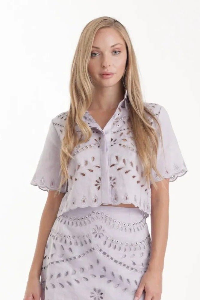 Woman wearing a light purple outfit with a matching top and skirt on a white background