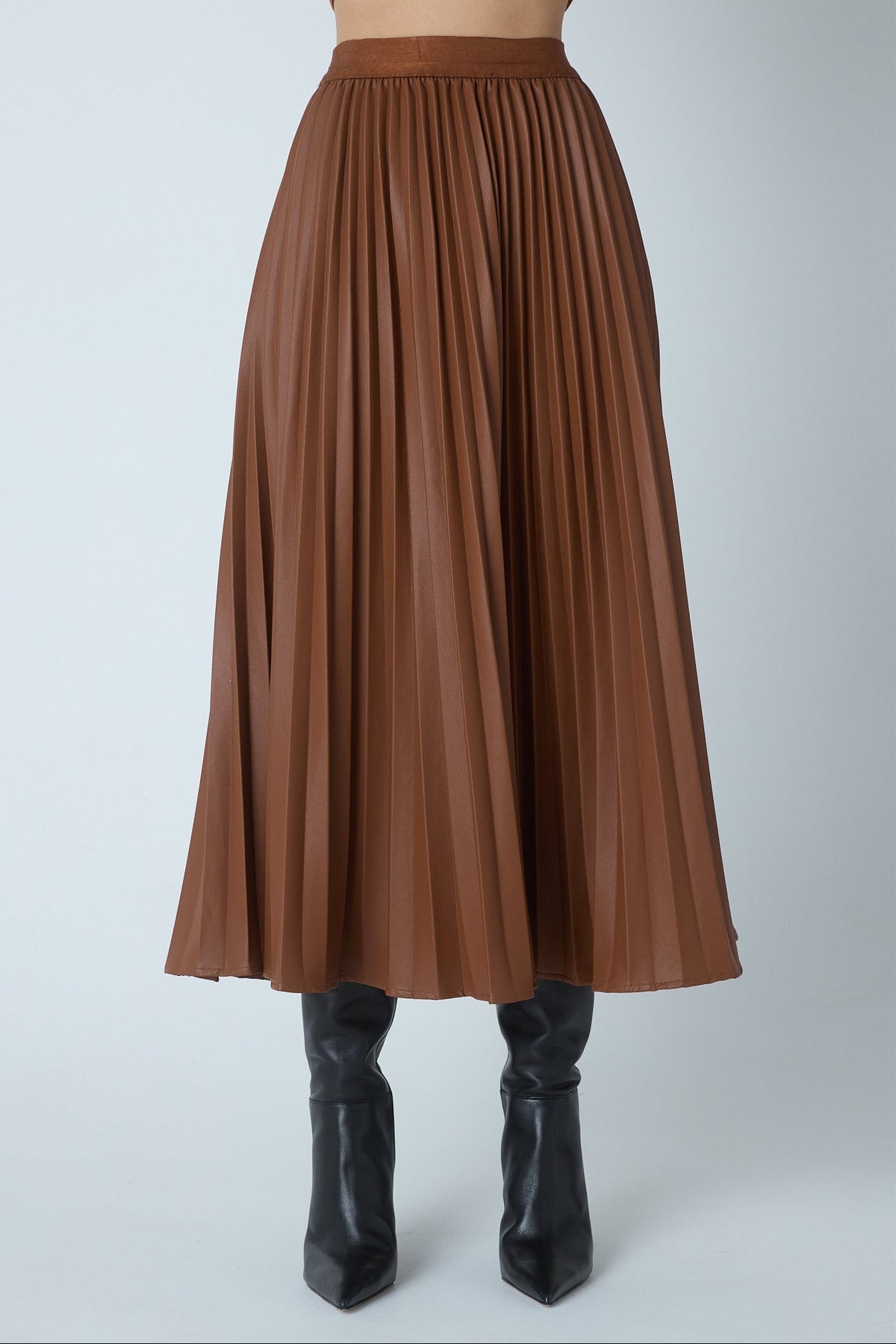 Model wearing the Nia copper faux leather pleated midi skirt by JS71